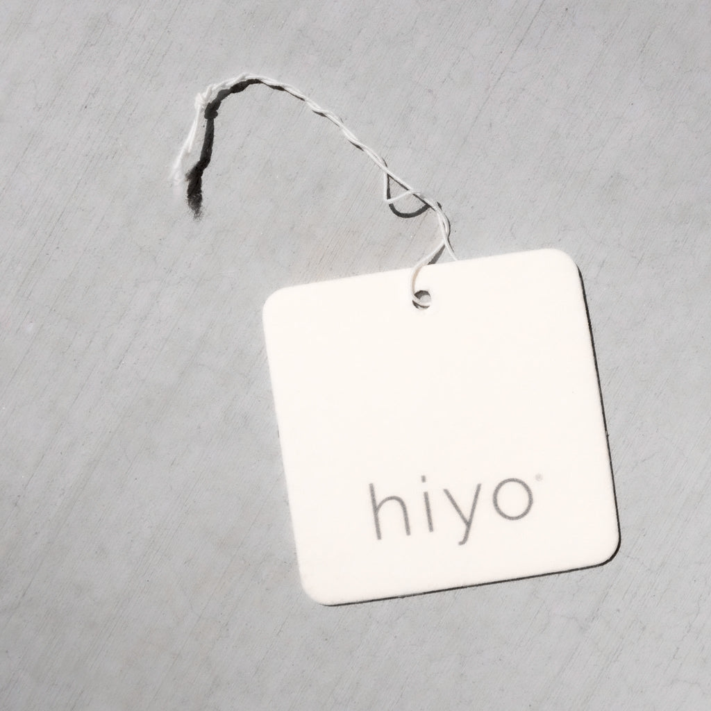 White square air freshener tag with "hiyo" text and black twine attachment.