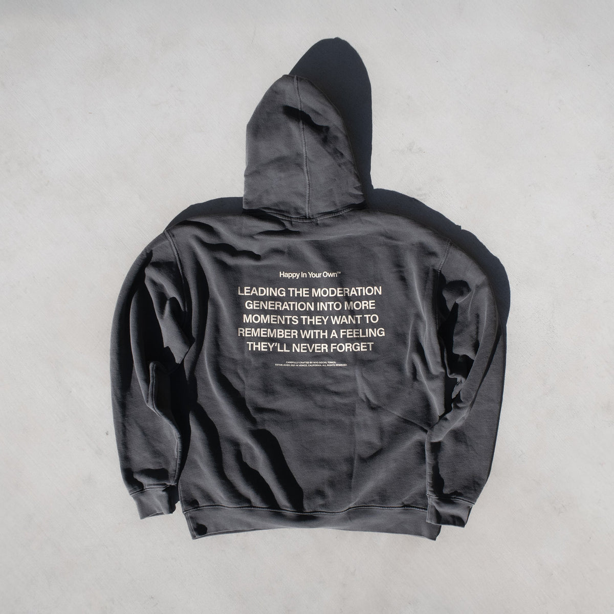 Charcoal gray zip-up hoodie with white text printed on the back and hood.