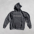 Charcoal gray hoodie with white text reading "IN THE SPIRIT OF BEING FREE" on the chest and front pocket.