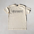 Cream colored short-sleeve t-shirt with black text reading "Happy in Your Own Est. 2021 Venice, CA" on the front.