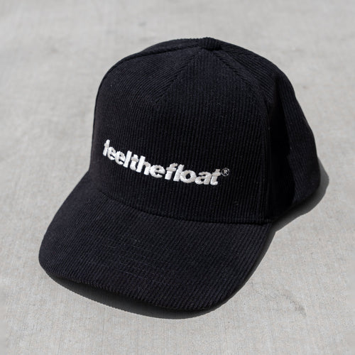 Black trucker hat with white "feel the float" text embroidered on the front.