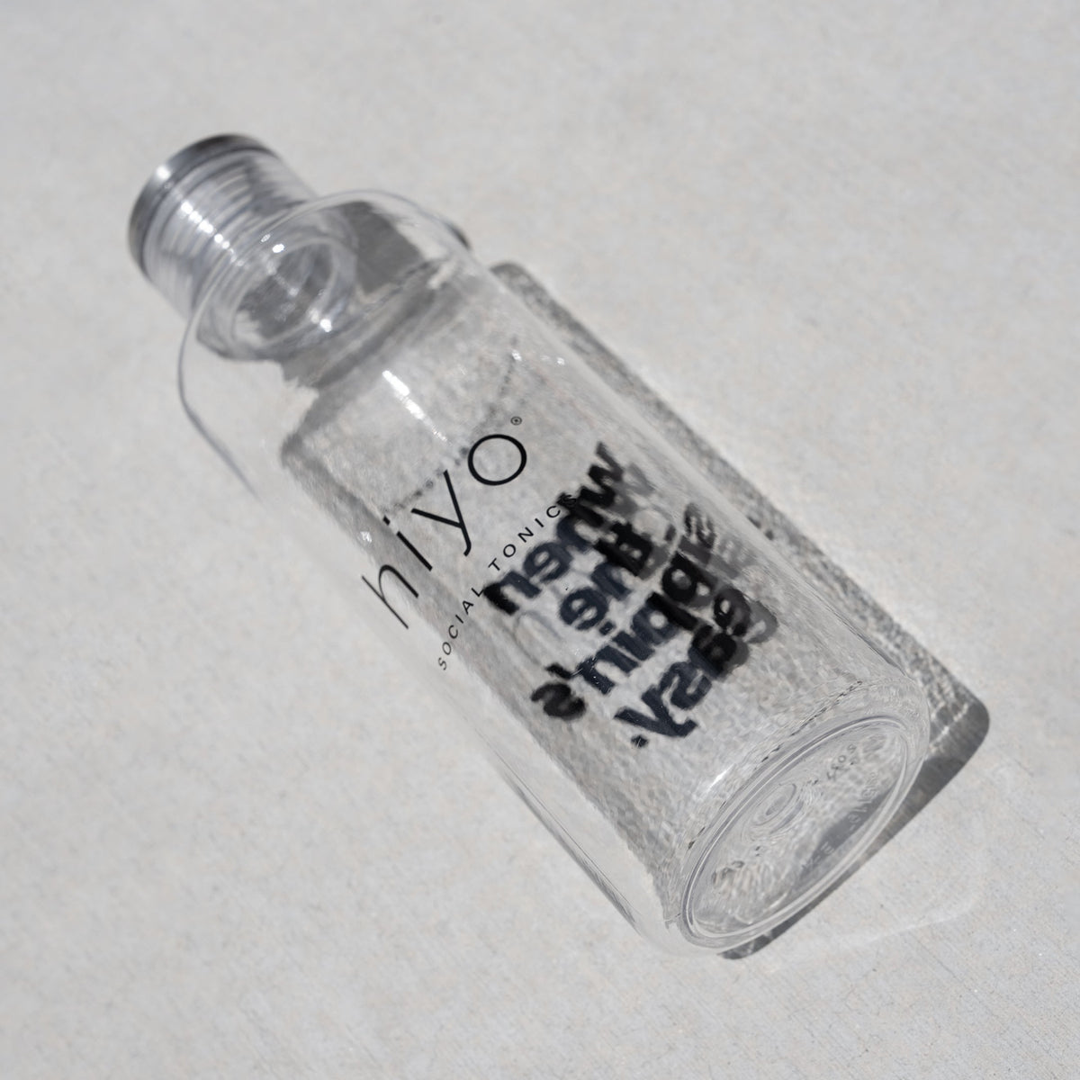 Clear plastic water bottle with "SIYO" branding and screw-on cap angled on white surface.